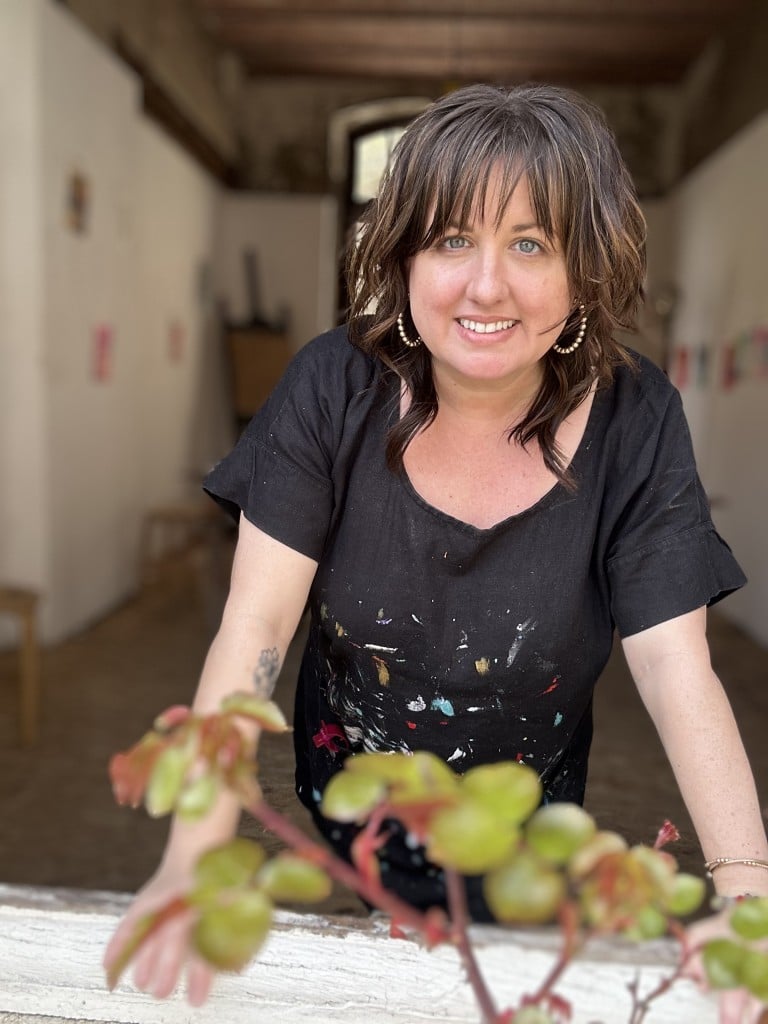Middle age woman with a black shirt smiling for the camera.